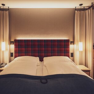 Doppelbettzimmer mit Bettzeug und Nachttischlampen  | © Davos Klosters Mountains 