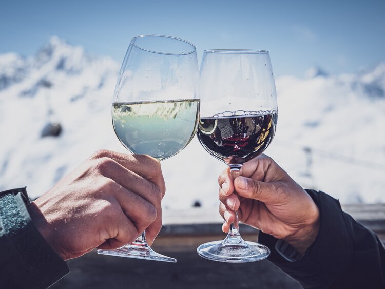 2 Hände die mit Weingläsern anstossen  | © Davos Klosters Mountains
