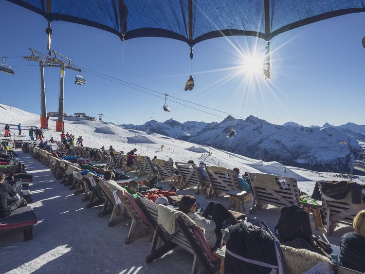 Gäste geniessen die Sonne in den Sonnenliegen im Chalet Güggel auf dem Jakobshorn. | © Davos Klosters Mountains