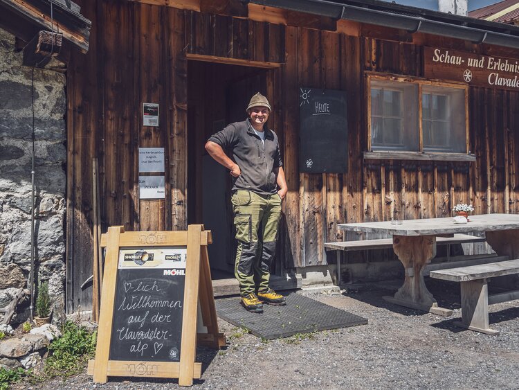 Der Alpmeister Manuel Gufler steht am Eingang zum Restaurant und zur Schaukäserei Clavadeler Alp. | © Davos Klosters Mountains