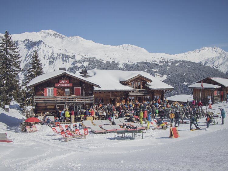 Berghaus alte Schwendi mit gefüllter Terrasse an einem sonnigen Wintertag. | © Davos Klosters Mountains