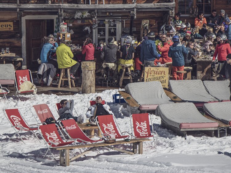 In Liegen, an der Bar wie auch auf der Terrasse geniessen Leute bergtypische Spezialitäten oder auch einfach die Wärme der Sonne.  | © Davos Klosters Mountains