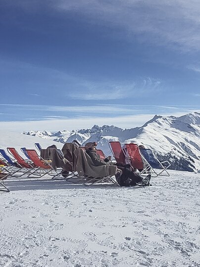 Rote Liegen stehen aufgereiht auf der Aussichtsterrasse der Gruobenalp. | © Davos Klosters Mountains