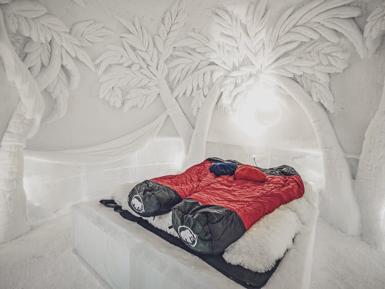 Kunstvolle Palmen aus Schnee zieren ein romantisches Zimmer im Iglu-Dorf. | © Davos Klosters Mountains