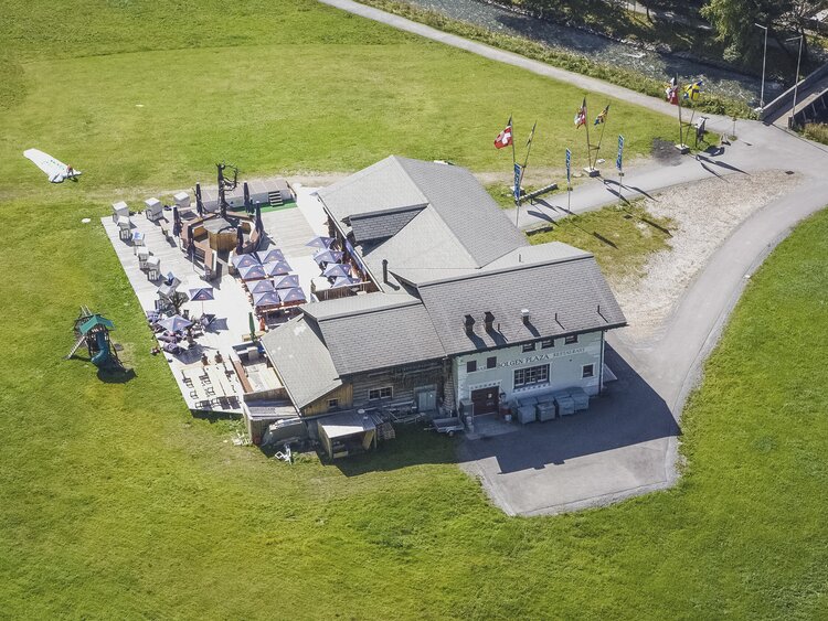 Das berühmte Bolgen Plaza mitten in einer saftig grünen Wiese am Fusse des Jakobshorns. | © Davos Klosters Mountains