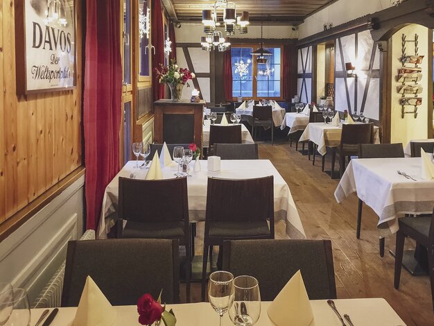 Eingedeckte Tische stehen im Steakhouse Ochsen für das Abendessen bereit. | © Davos Klosters Mountains