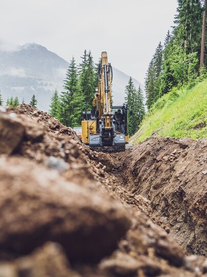 Im Sommer gräbt ein Bagger einen Graben auf der Talabfahrt Jakobshorn. | © Davos Klosters Mountains
