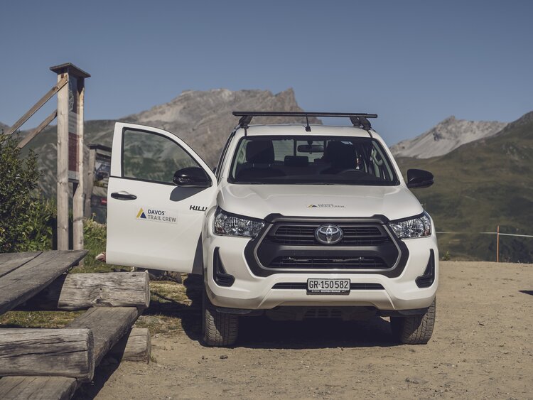Das Auto der Trail Crew Davos steht mit offener Türe da. | © Davos Klosters Mountains