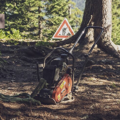 Eine Maschien zur Verdichtung des Bodens steht auf dem Trail im Wald. | © Davos Klosters Mountains