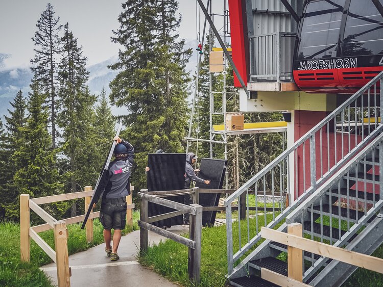 Die Module für die Solaranlage werden zum Gerüst an der Talstation der 2. Sektion Jakobshorn getragen.  | © Davos Klosters Mountains