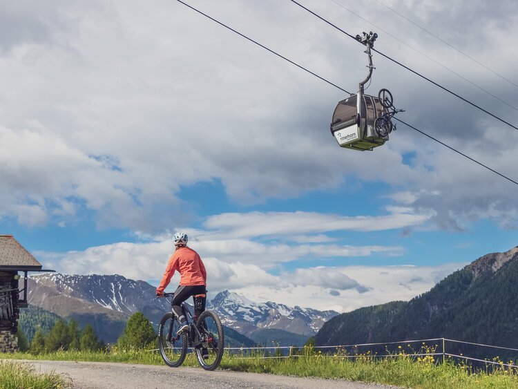 Bikerin vor einer Gondel des Rinerhorns. | © Davos Klosters Mountains