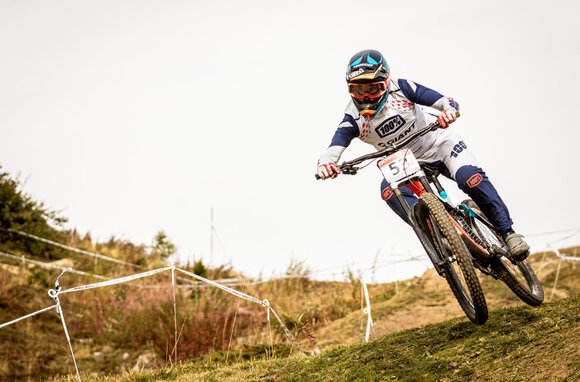 In voller Montur fährt der Downhill  Biker an einem Rennen mit.  | © Matteo Manno