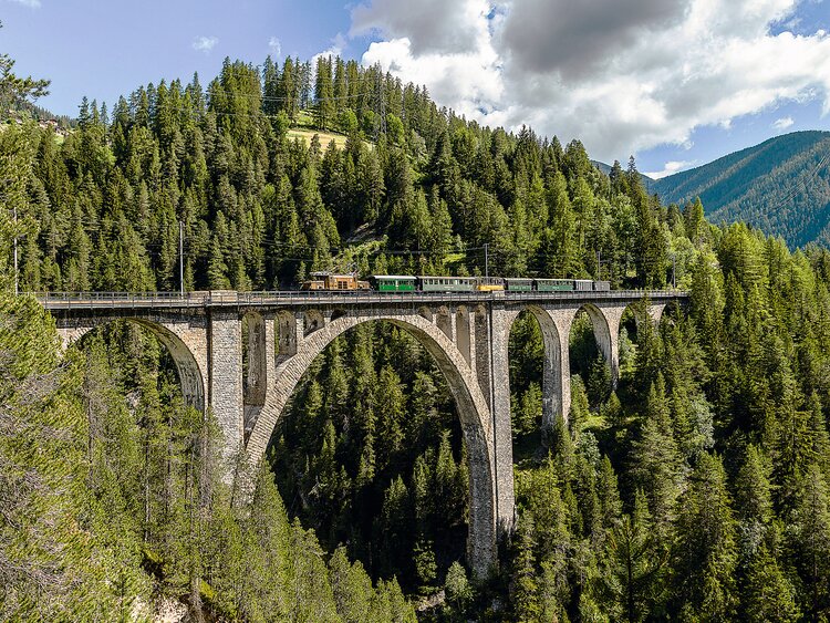 Der Nostalgiezug mit der Krokodil-Lokomative fährt über das Viadukt in der Zügenschlucht.  | © Andrea Badrutt