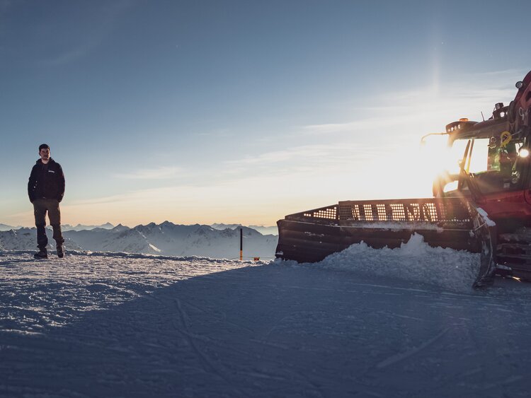 Der Fahrer Nino steht neben seinem Pistenbully auf dem Weissfluhgipfel.  | © Davos Klosters Mountains