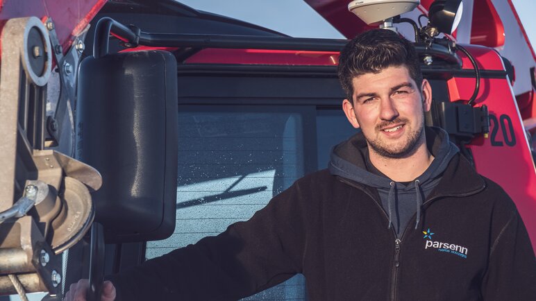 Nino, Pistenbully-Fahrer auf Parsenn, posiert vor seinem riesen Fahrzeug. | © Davos Klosters Mountains