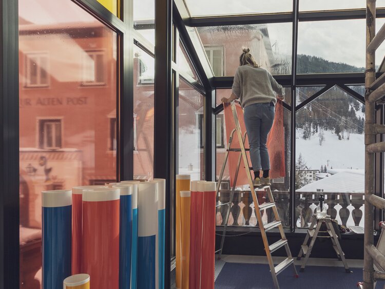 Mit Folien in verschiedenen Farben werden die Scheiben des Wintergartens für die Eröffnung des Restaurants Piz Piz umgestaltet.  | © Davos Klosters Mountains