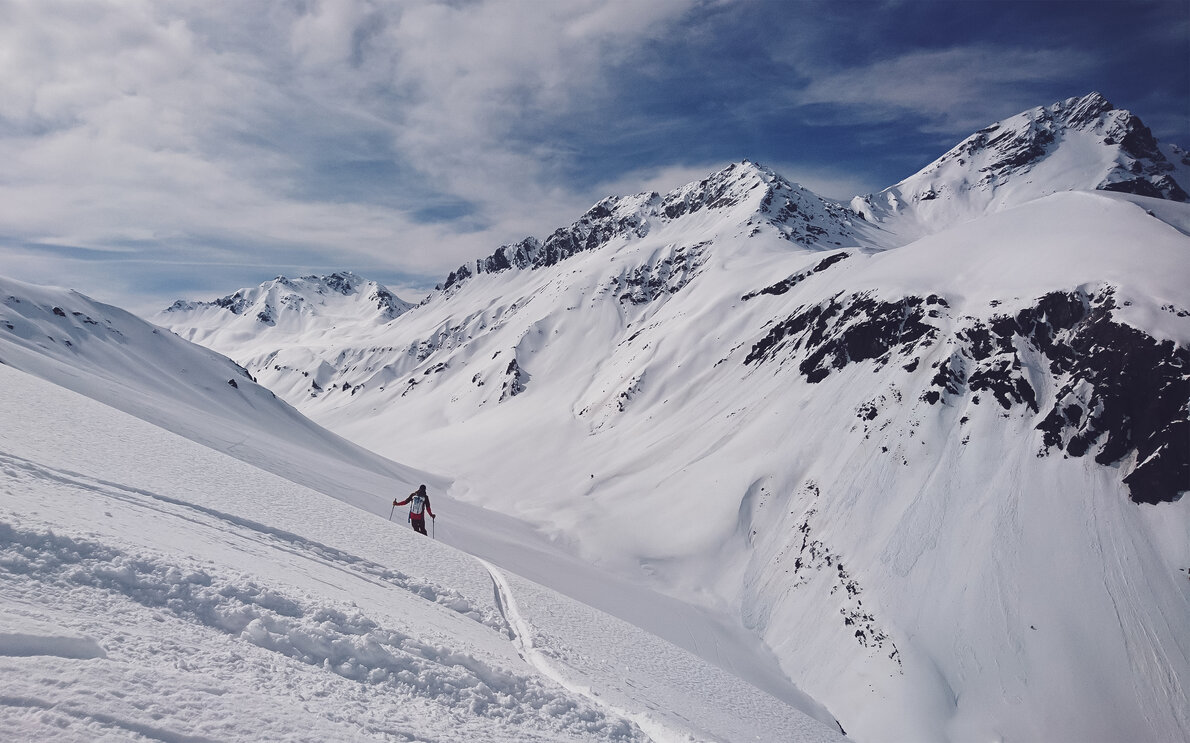 Ein Skitourengänger geht durch die verschneite Berglanschaft bei Davos.  | © Davos Klosters Mountains