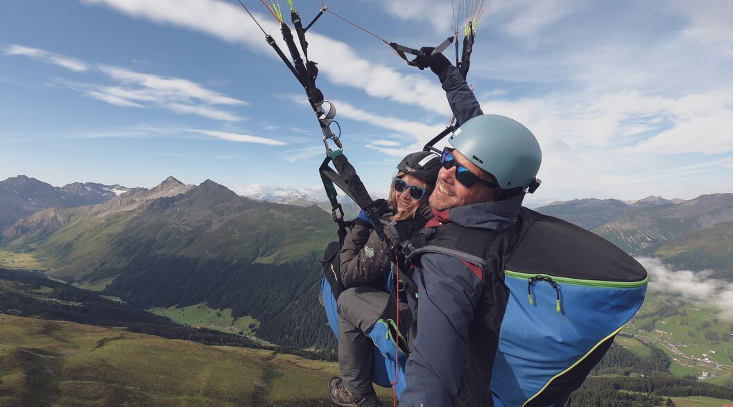 Selfie beim Paragliding Flug vom Jakobshorn, das Sertigtal im Hintergrund. | © Davos Klosters Mountains