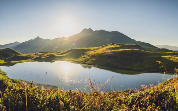 In grünen Hügeln eingebettet liegt der kleine Bergsee Grünsee. | © Davos Klosters Mountains
