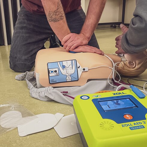 Männliche Person führt Herzdruckmassage an Dummy aus.  | © Davos Klosters Mountains 