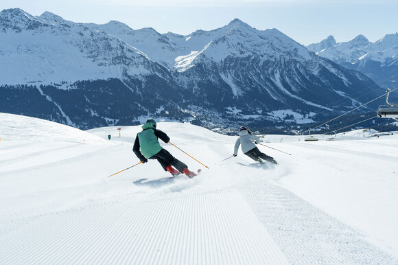 2 Skifahrer schwingen auf die Talabfahrt zu | © Davos Klosters Mountains 