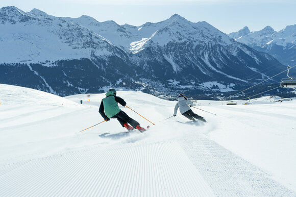 2 Skifahrer schwingen auf die Talabfahrt zu | © Davos Klosters Mountains 