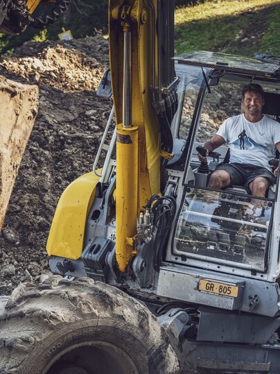 Andreas Grassel arbeitet mit dem gelben Menzi Muck Bagger. | © Davos Klosters Mountains