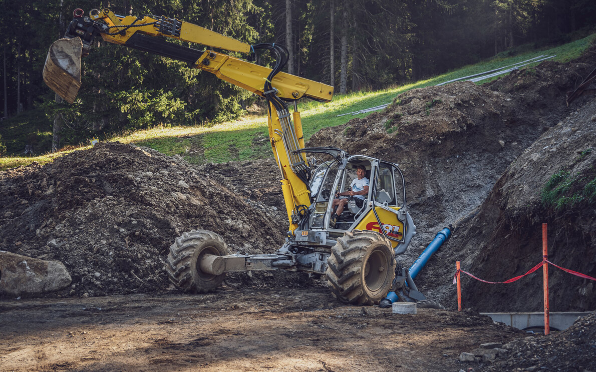 Mit dem gelben Menzi Muck Bagger arbeitet Mitarbeiter Andreas Grassel an der neuen Talabfahrt Jakobshorn.  | © Davos Klosters Mountains