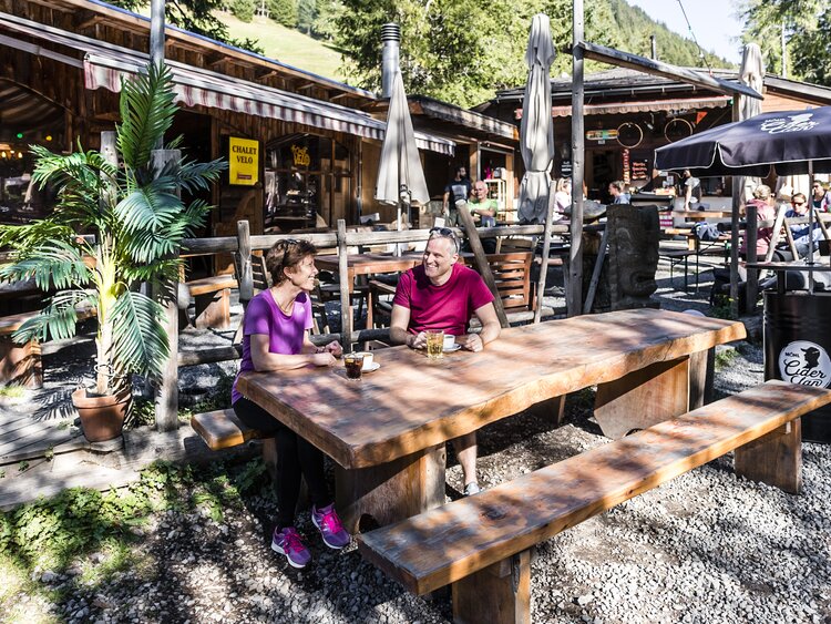 2 Personen sitzen am Tisch beim Restautant Chalet Velo Davos. | © DDO Martin Bissig