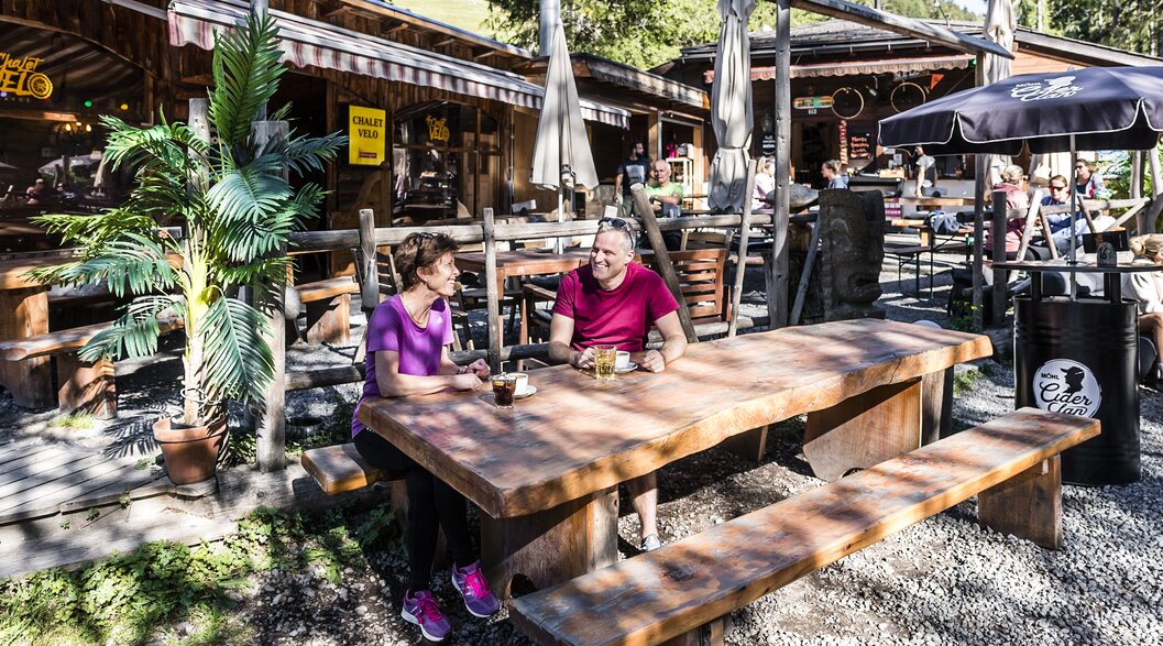 2 Personen sitzen am Tisch beim Restautant Chalet Velo Davos. | © DDO Martin Bissig