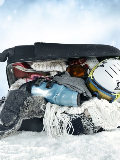 Offener, vollbepackter Koffer mit Winterkleider  | © Davos Klosters Mountains 