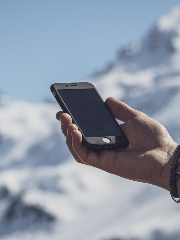 Cell phone in the mountains | © Davos Klosters Mountains A hand is holding a cell phone. | © Davos Klosters Mountains