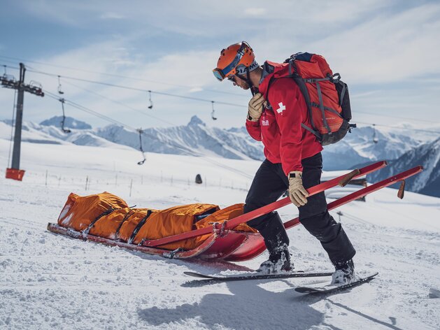 SOS Patrouilleur beim Abtransport einer verletzten Person mit Rettungsschlitten | © Davos Klosters Mountains SOS Patrouilleur beim Abtransport einer verletzten Person mit Rettungsschlitten | © Davos Klosters Mountains