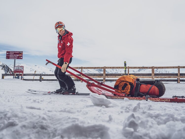 SOS Patrouilleur beim Einsatz zum Unfallort mit Rettungsschlitten und Rettungssack  | © Davos Klosters Mountains 