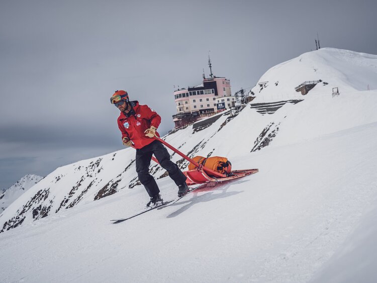 SOS Patrouilleur auf dem Weg zum Unfallort mit Rettungsschlitten und Rettungssack   | © Davos Klosters Mountains 