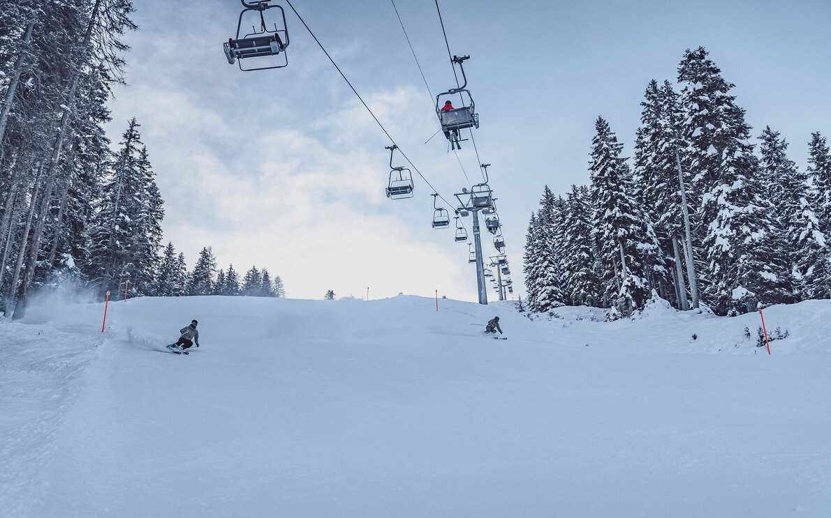 Der 2er-Sessellift Carjöl mit Skifahrer auf der Talabfahrt Piste «Davos Vertical». | © Davos Klosters Mountains