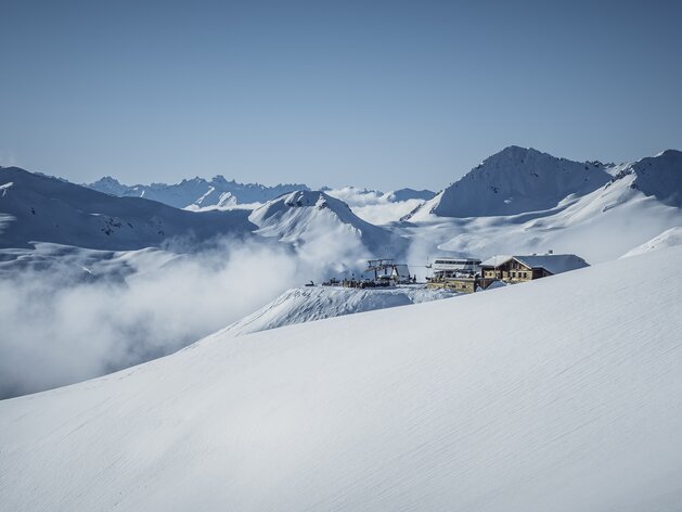Jatzhütte mit Bergpanorama im Hintergrund. | © Davos Klosters Mountains