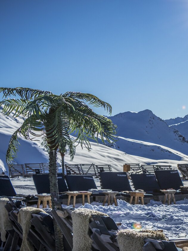 Liegestühle und Palmen auf der Jatzhütte mit Blick ins Sertigtal. | © Davos Klosters Mountains
