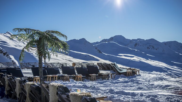 Liegestühle und Palmen auf der Jatzhütte mit Blick ins Sertigtal. | © Davos Klosters Mountains