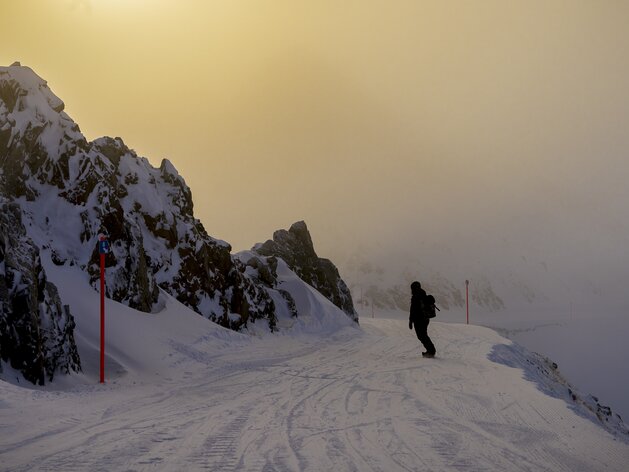 Snowbaorden bei Sonnenaufgang | © Davos Klosters Mountains Snowboarder geniesst erste Abfahrt vom Jakobshorn Gipfel bei Sonnenaufgang. | © Davos Klosters Mountains