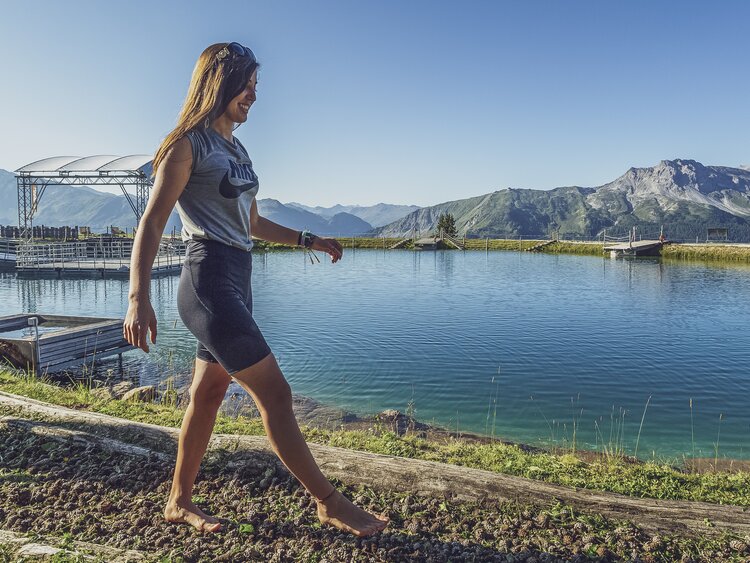 Junge Frau gönnt ihren Füssen den Massage Weg im Madrisa Hof. | © Davos Klosters Mountains