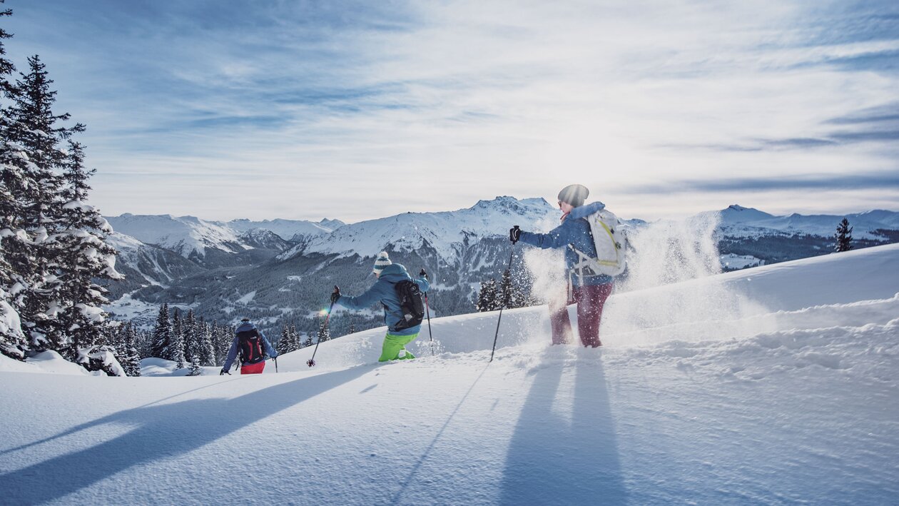 Three people enjoy snowshoeing through the deep snow. | © Destination Davos Klosters