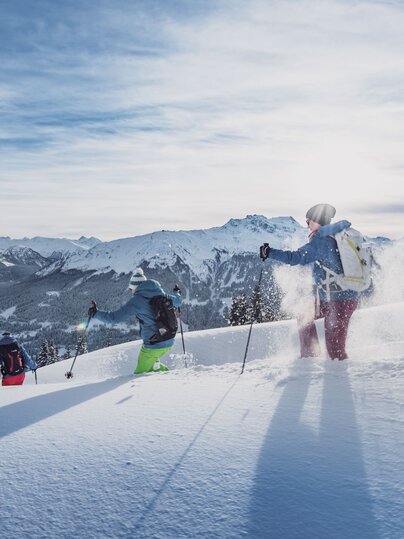 Three people enjoy snowshoeing through the deep snow. | © Destination Davos Klosters