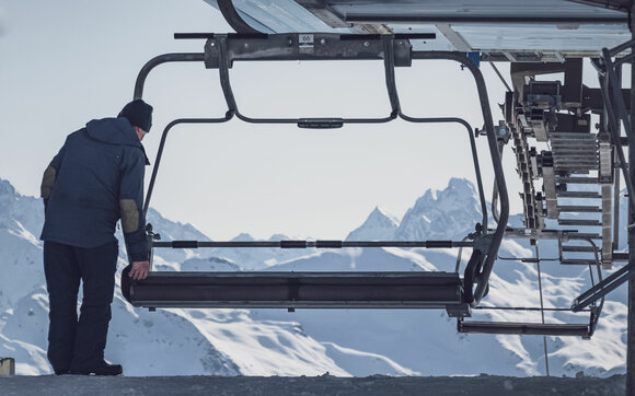 Employees on Parsenn fold up the chairlift seats at Meierhoftäli at the start of the ski day. | © Davos Klosters Mountains