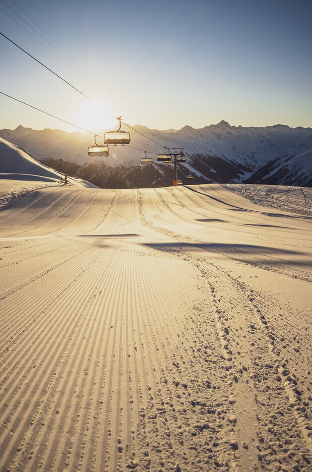 Sonnenaufgang und frisch präparierte Piste am Dorftäli. | © Davos Klosters Mountains
