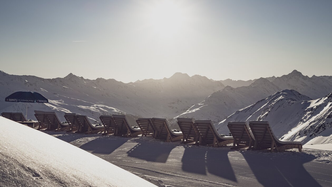 Liegestühle im Schnee mit Blick in die Berge. | © Davos Klosters Mountains