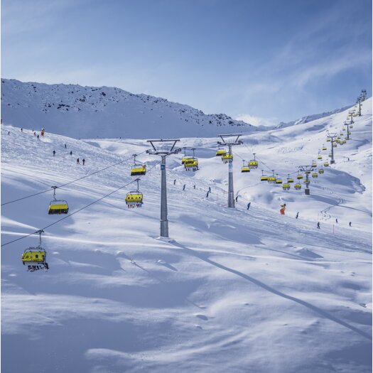Totalp Sesselift erleuchtet mit seinen gelben Wetterschutzhauben im Sonnenlicht. | © Davos Klosters Mountains