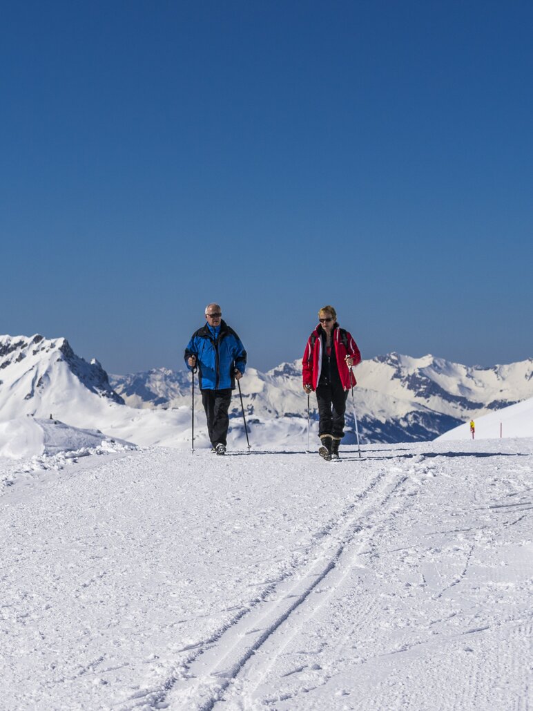 Winter hiking Pischa | © Davos Klosters Mountains Man and woman enjoy winter hike and blue sky. | © Davos Klosters Mountains