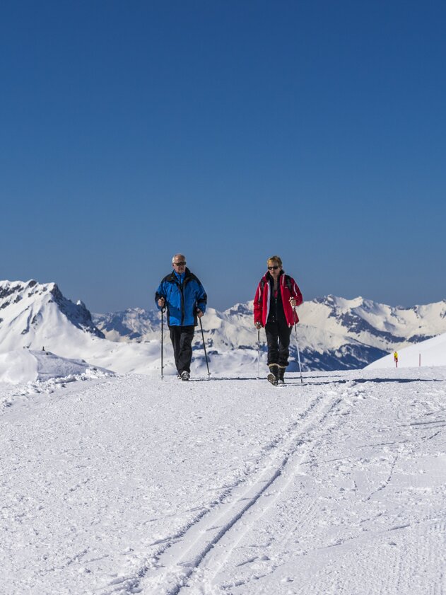Winter hiking Pischa | © Davos Klosters Mountains Man and woman enjoy winter hike and blue sky. | © Davos Klosters Mountains