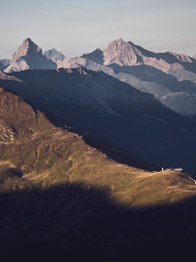 Blick in Richtung Rinerhorn, mit der von der Sonne beleuchteten Hubelhütte, das Tinzenhorn im Hintergrund. | © Davos Klosters Mountains